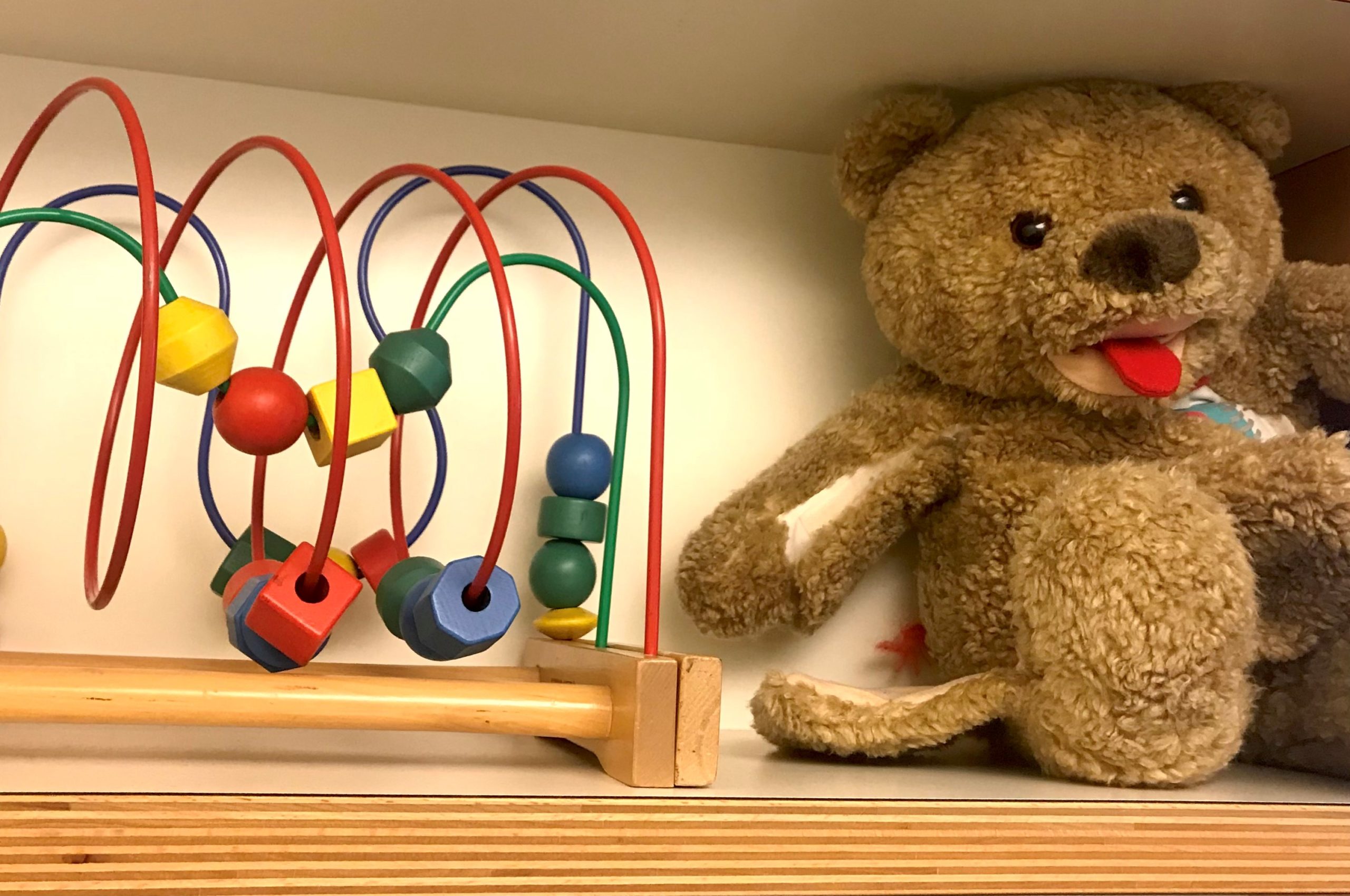 Buntes Motorikspielzeug in einem Regal