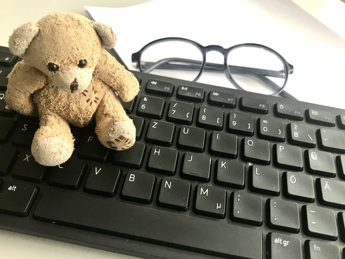 Keyboard with a small teddy bear and reading glasses