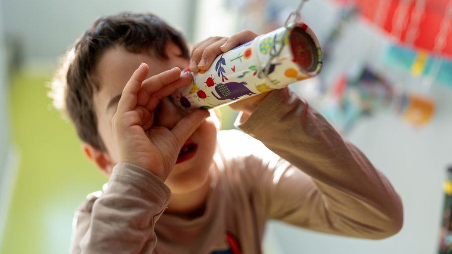L'enfant regarde à travers un kaléidoscope